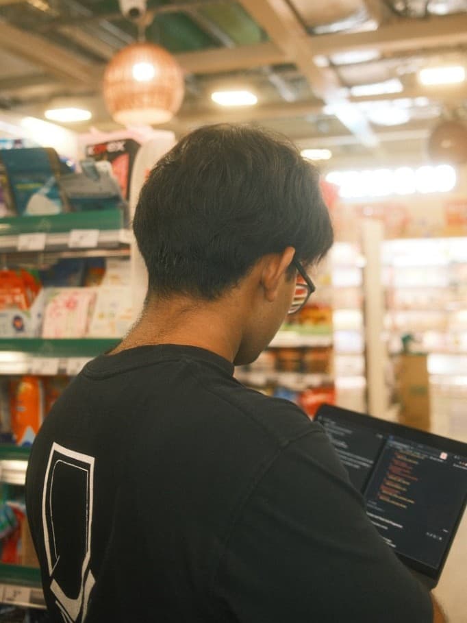 Rudy working on a laptop, seen from behind